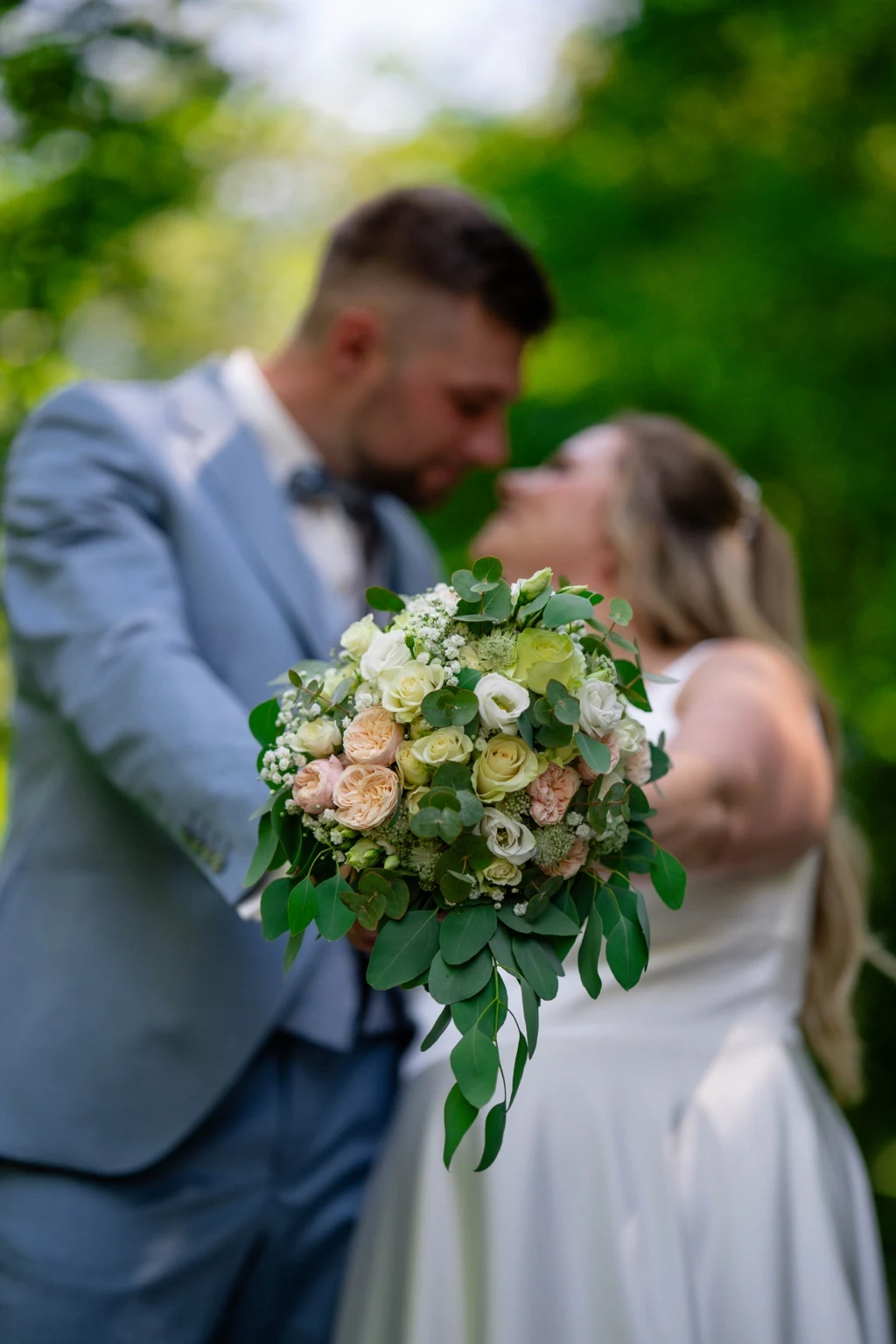 Brautstrauß mit Rosen im Vordergrund beim Brautpaarshooting am Haus Egelborg in Legden