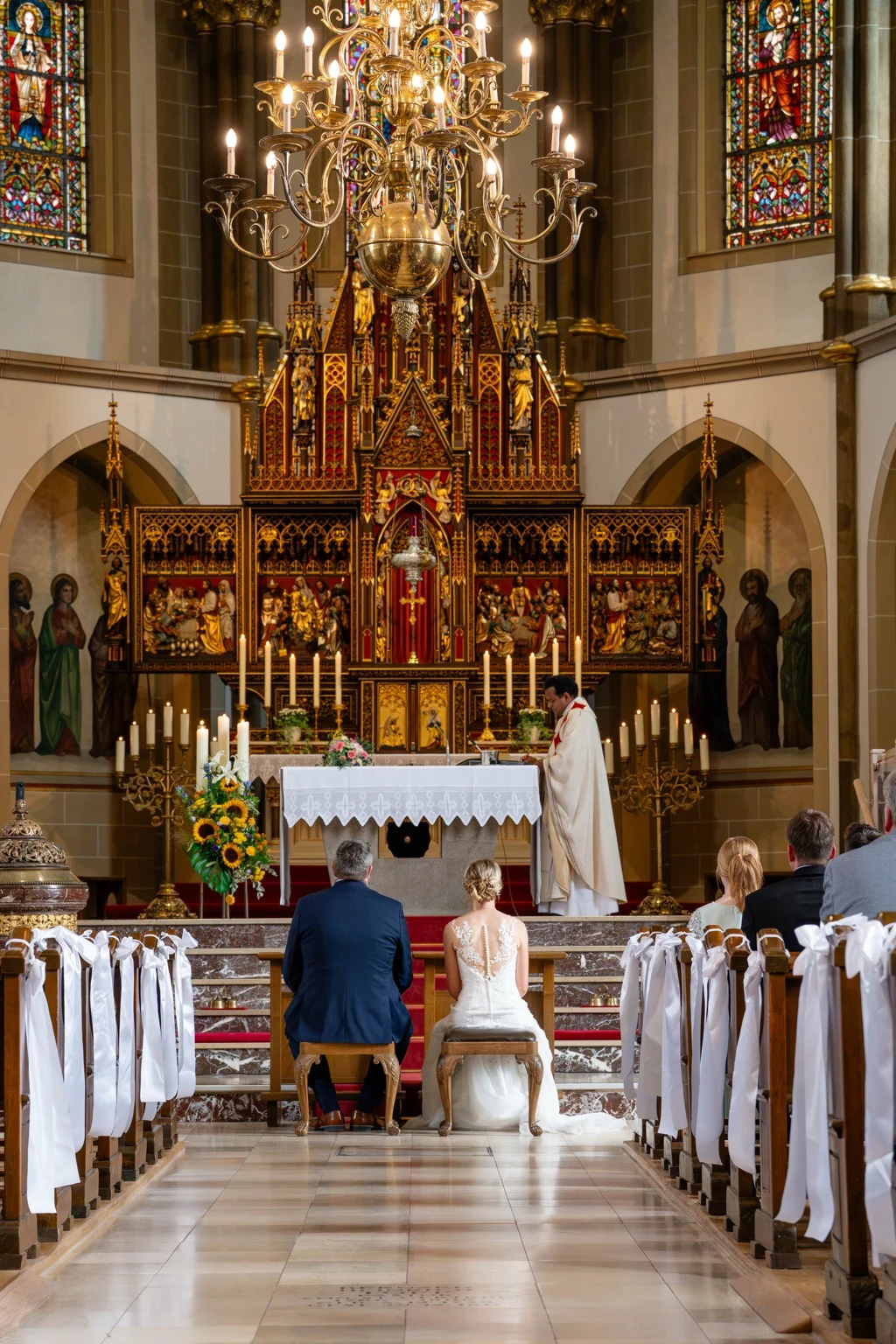 Brautpaar sitzt während der Trauung vor dem Altar in St. Gertrud in Lohne