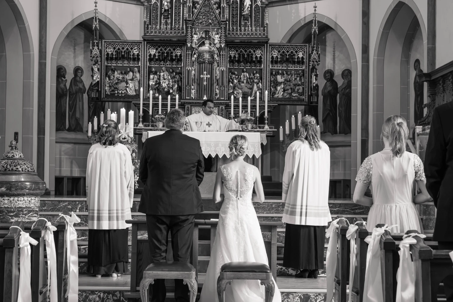 Brautpaar und Messdiener vor dem Altar in St. Gertrud in Lohne, in Schwarz-Weiß